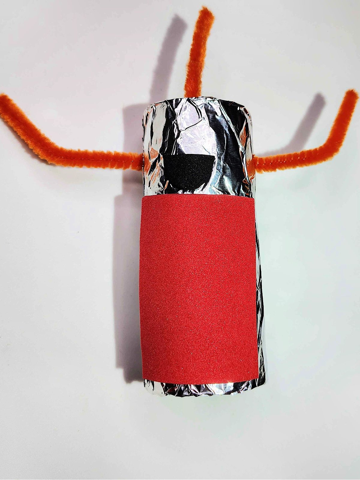 Toilet Paper Roll Craft- Step 5- Red rectangle and black smile added to alien - Kids Activities Blog
