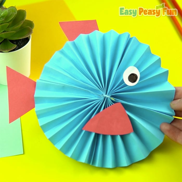 construction paper crafts - fish made from accordion folded construction paper in blue with red fins held by hand