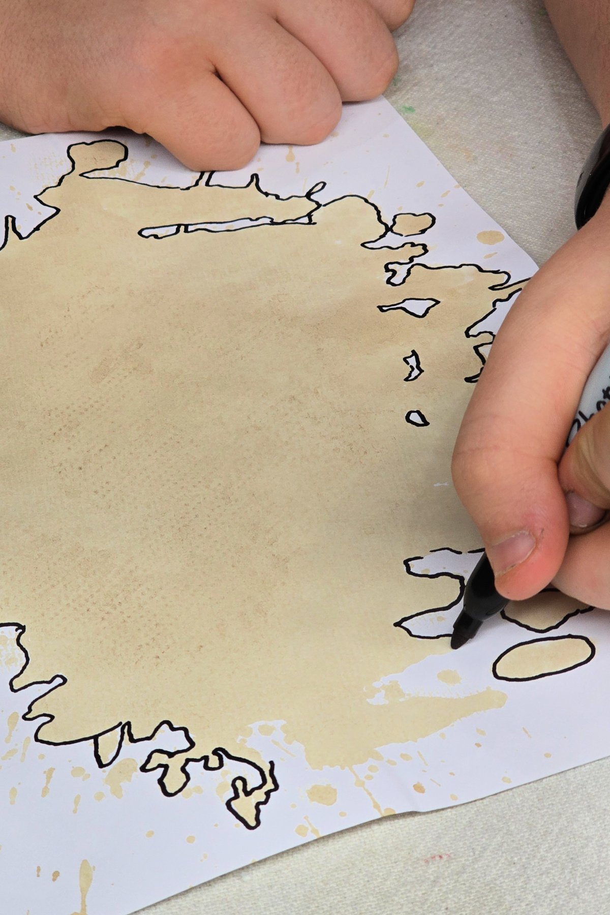 step 3 - using a permanent marker to trace around the edge of the dry coffee spill - kids activities blog