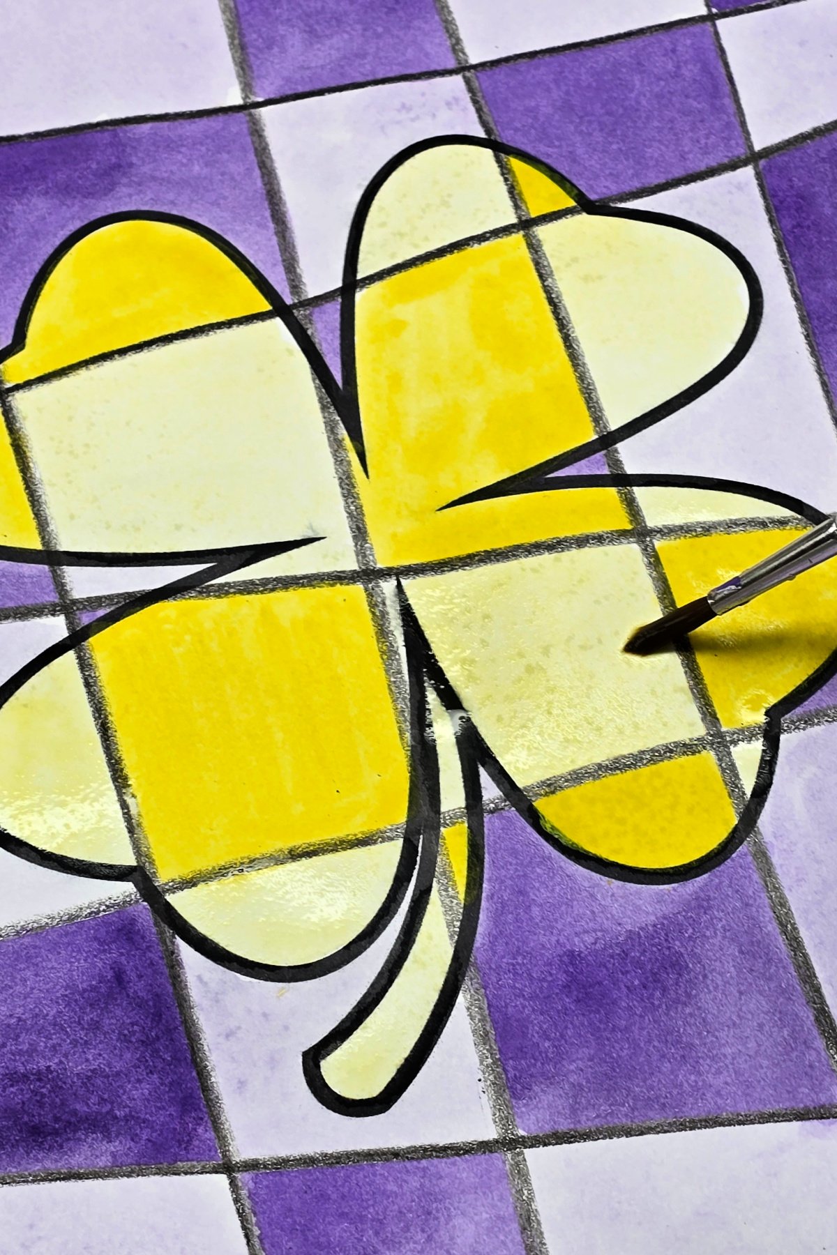 step 5 - using a lighter value of yellow watercolor to complete the shamrock design - kids activities blog